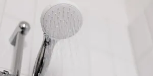 Un cabezal de ducha encendido con agua fluyendo.