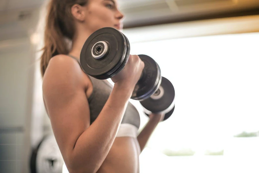A woman working out with a dumbbell set