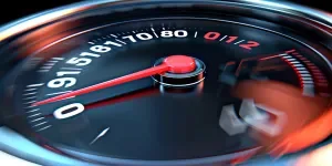 A speedometer with white numbers and a red arrow