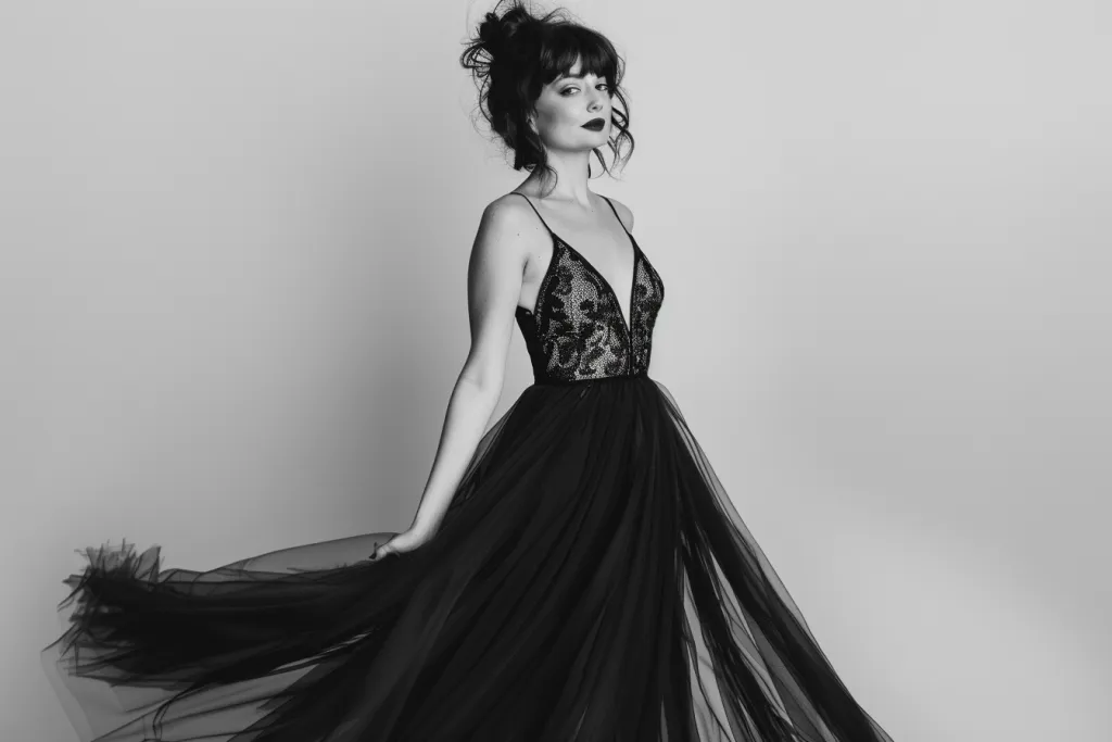 A woman is wearing an elegant black tulle gown with thin straps and lace details