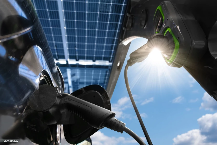 Black electric car charging under a solar carport
