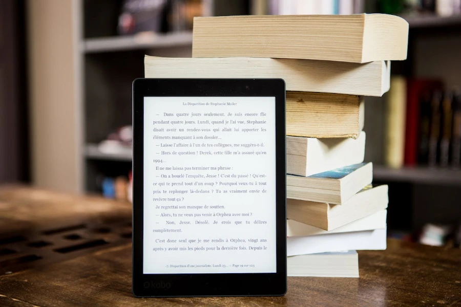 E-reader standing up in front of paperback books