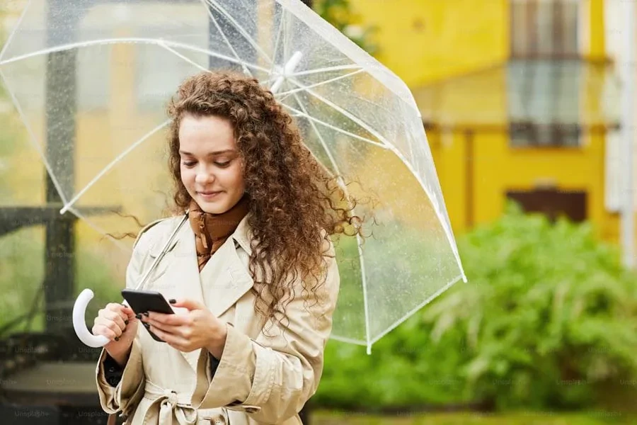 girl wearing a beige trench coat under the rain