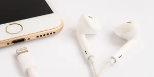 نموذج iPhone بالحجم الطبيعي ونموذج Apple EarPods الجديد على خلفية بيضاء