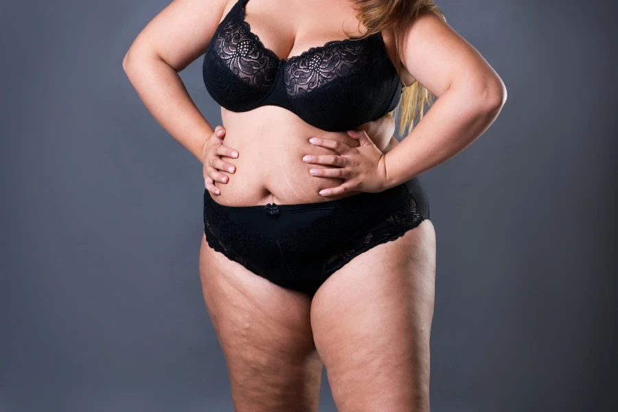 Shot of a young woman posing in her underwear against a grey background