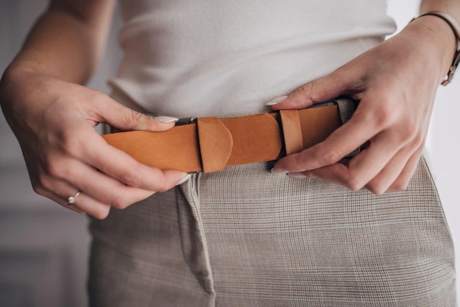 Unrecognizable elegant woman wearing modern leather belt.