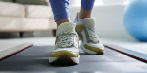 Woman training on walking treadmill at home