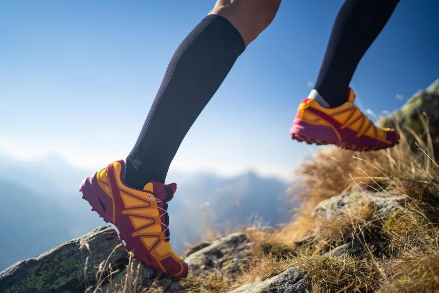 ноги женщины-бегуна по пересеченной местности в спортивных компрессионных носках