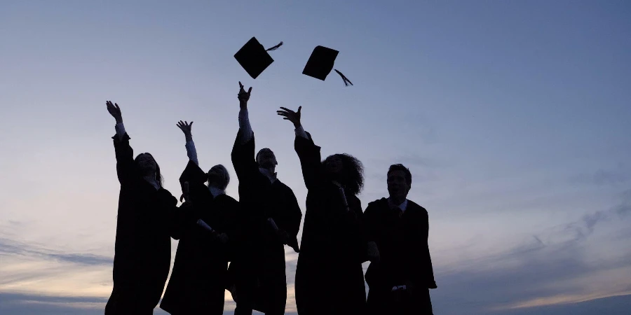Silhouette d'étudiants diplômés jetant des casquettes en l'air
