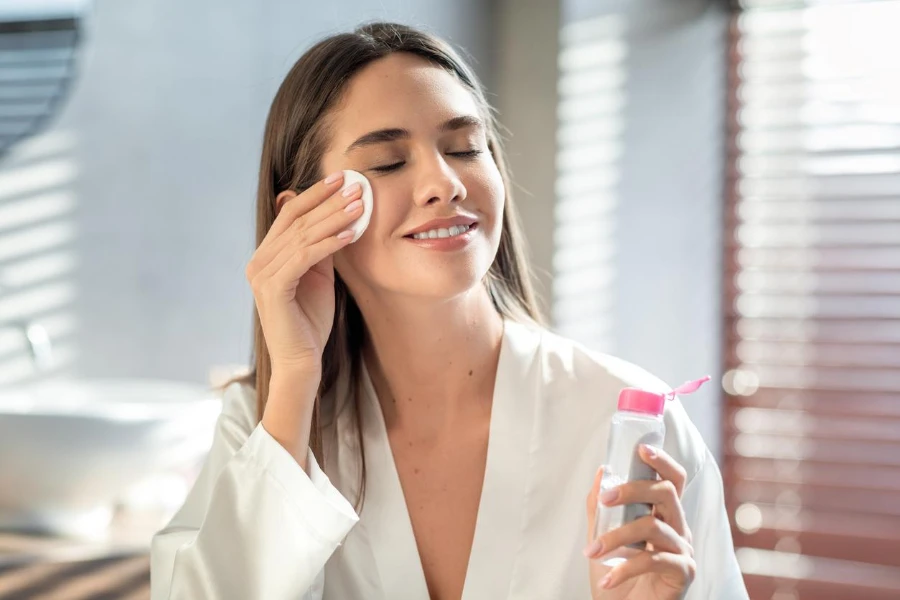 beautiful Smiling Woman Cleansing Skin With Micellar Water