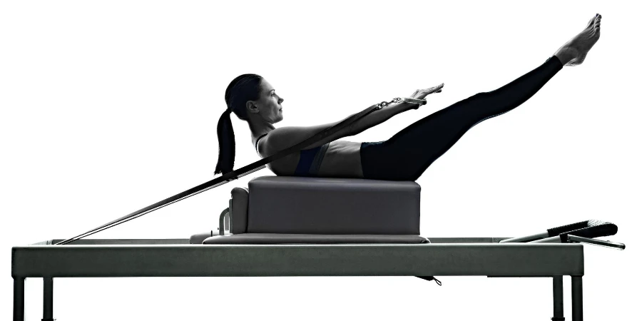 one caucasian woman exercising Pilates reformer exercises fitness