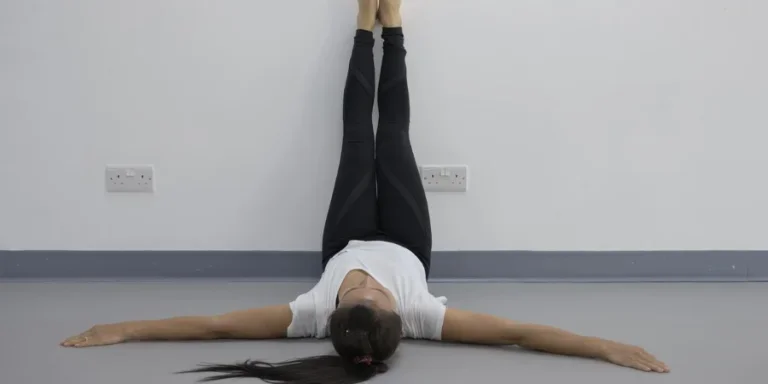Yoga woman feet up relaxing on wall background