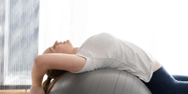 Teenager practicing Pilates and stretching on a gymnastic ball