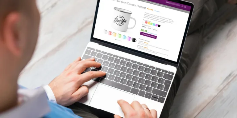 Man working with a laptop and creating his own products by using print on demand service online
