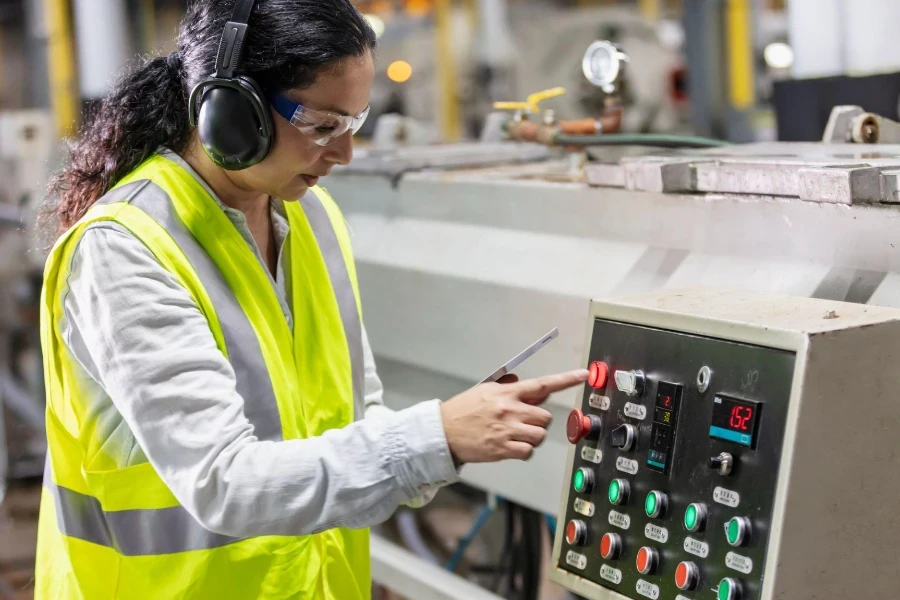 A mature Hispanic woman in her 40s working in a plastics factory