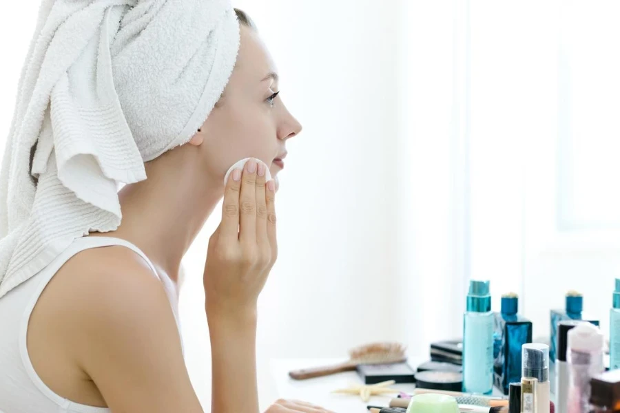 Young woman removing makeup from her face