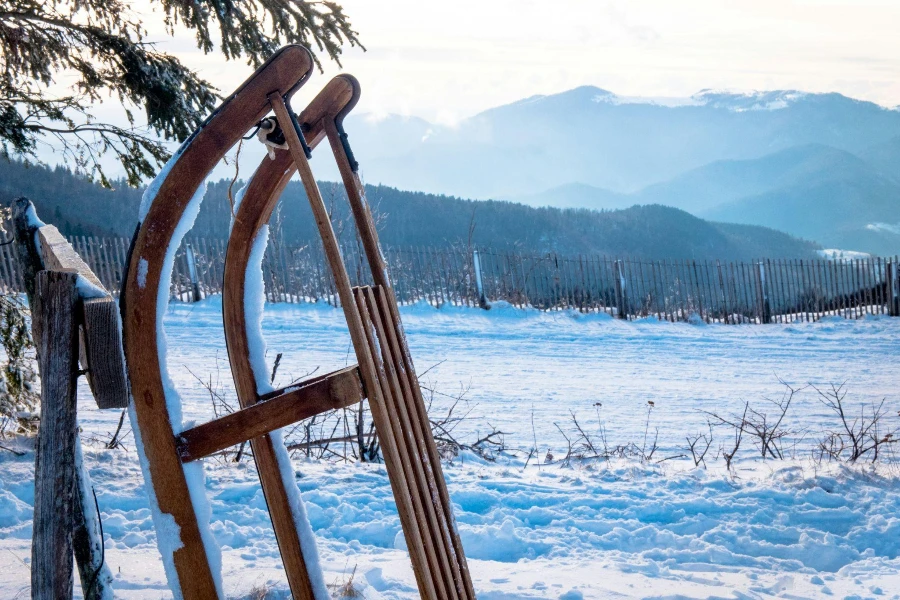 A wooden sled sitting on top of a snow covered filed