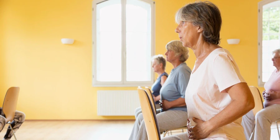 Primo piano della lezione di yoga attiva delle donne anziane sulle sedie