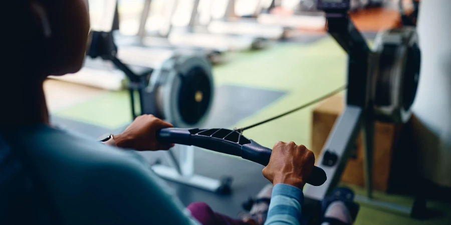 American athletic woman using rowing machine
