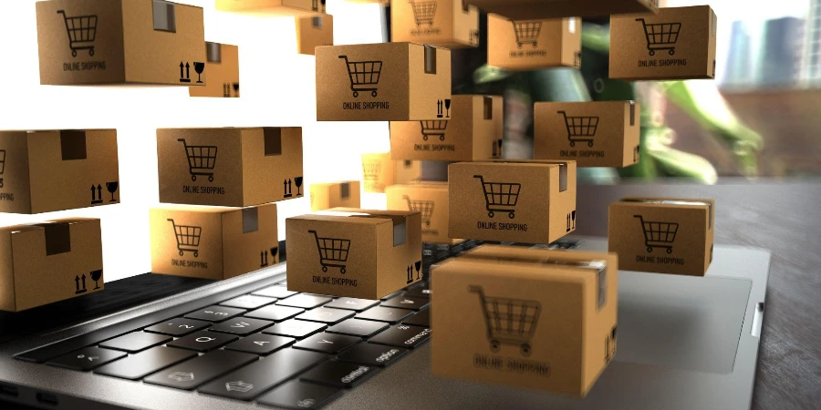 Üzerinde Online Alışveriş yazan bir dizüstü bilgisayarda küçük nakliye paketleri