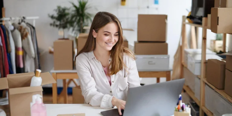 Young woman dropshipper with laptop working at home