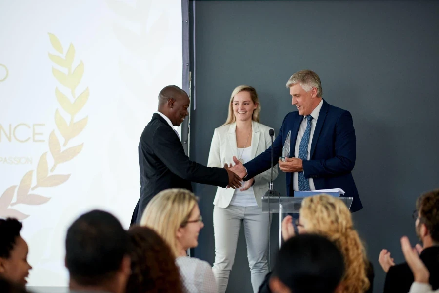 Shot of a young businessman being awarded a prize during an awards giving ceremony at a conference