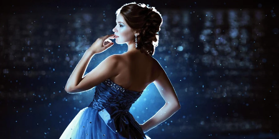 Schöne Dame im blauen Kleid, die am Meer spaziert