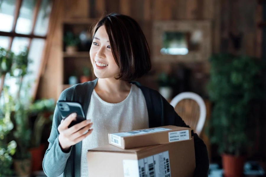 beautiful smiling young Asian woman with smartphone