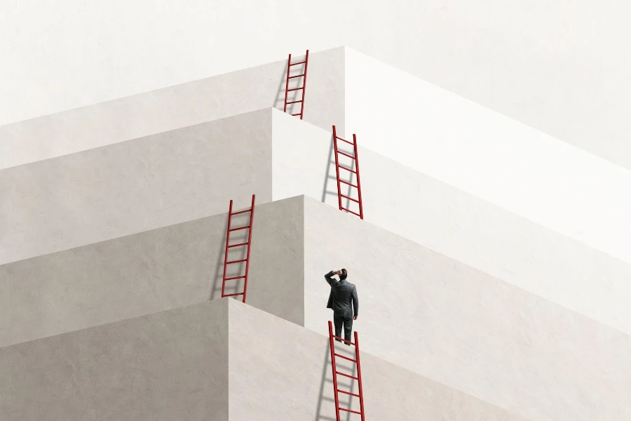 A man looks up at a series of ladders that lead him to the next level