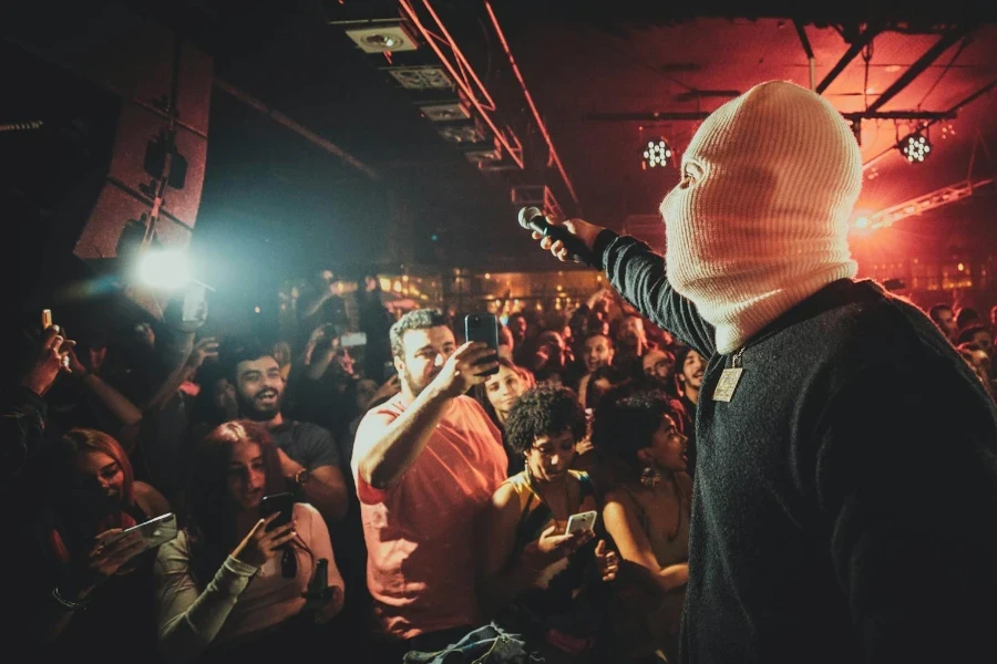 A Person Wearing Beige Balaclava Performing in Front of the Audience