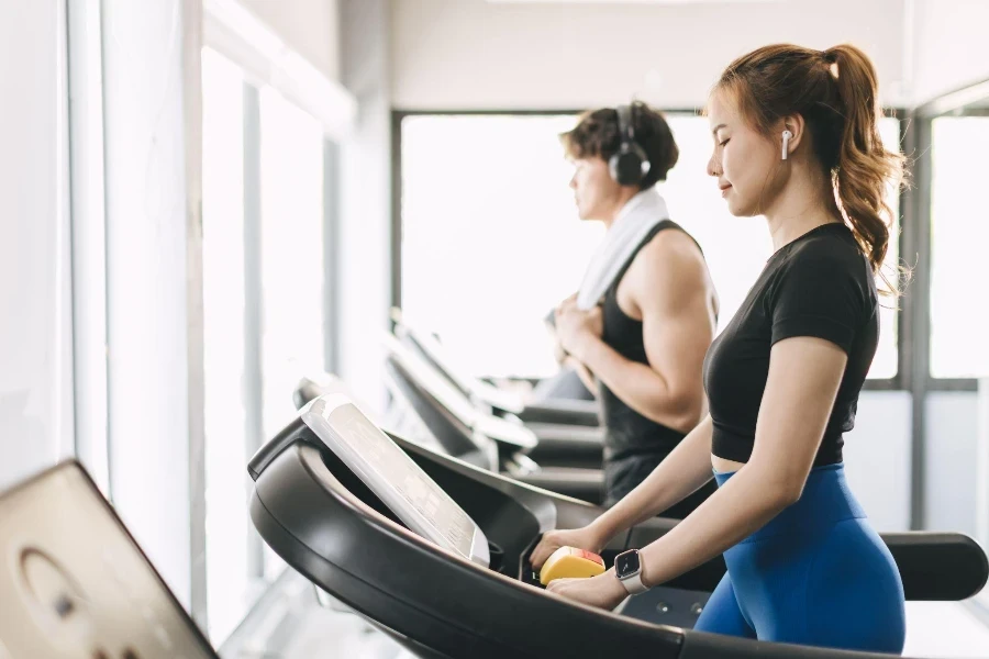 Young people running on a treadmill in health club