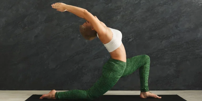 woman training yoga in hero pose in gym at grey background