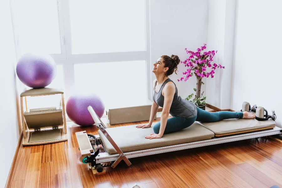 woman doing Pilates exercises on reformer bed at home