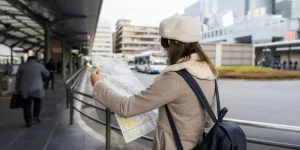 Young tourist Woman stand reading bus map at bus stop
