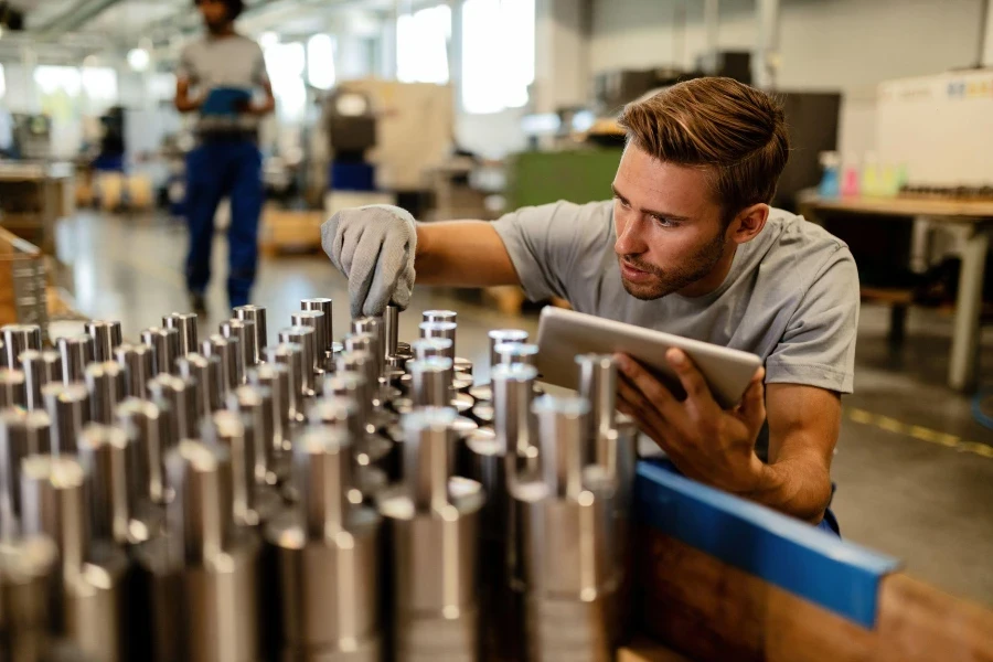 Young metal worker using touchpad