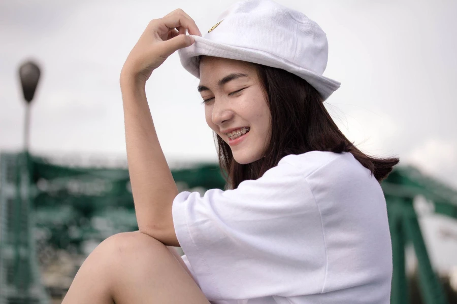 Camiseta branca para menina adulta tailandesa linda garota relaxa e sorri