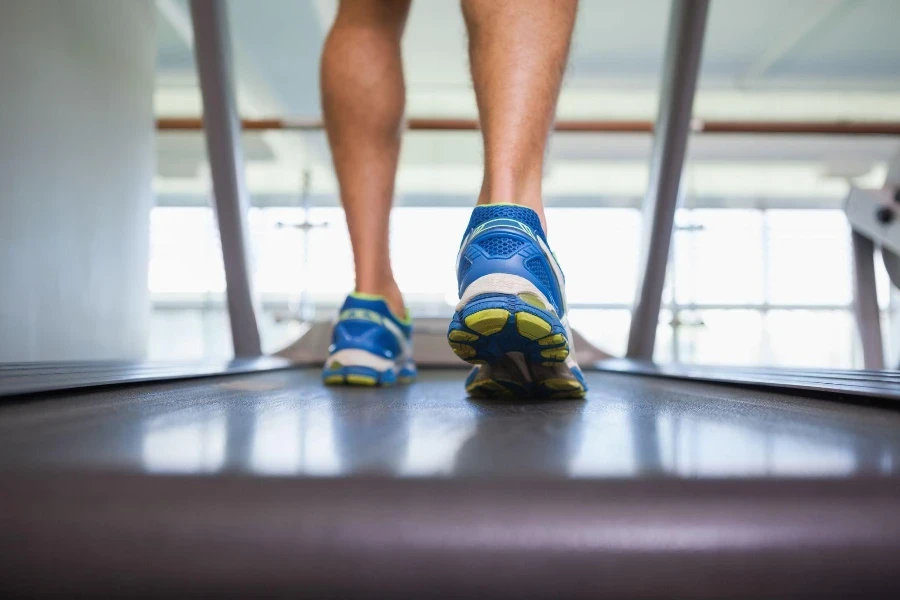 Seção baixa da vista traseira de um homem andando sobre uma plataforma