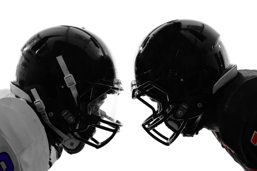 two American football players face to face in silhouette shadow on white background