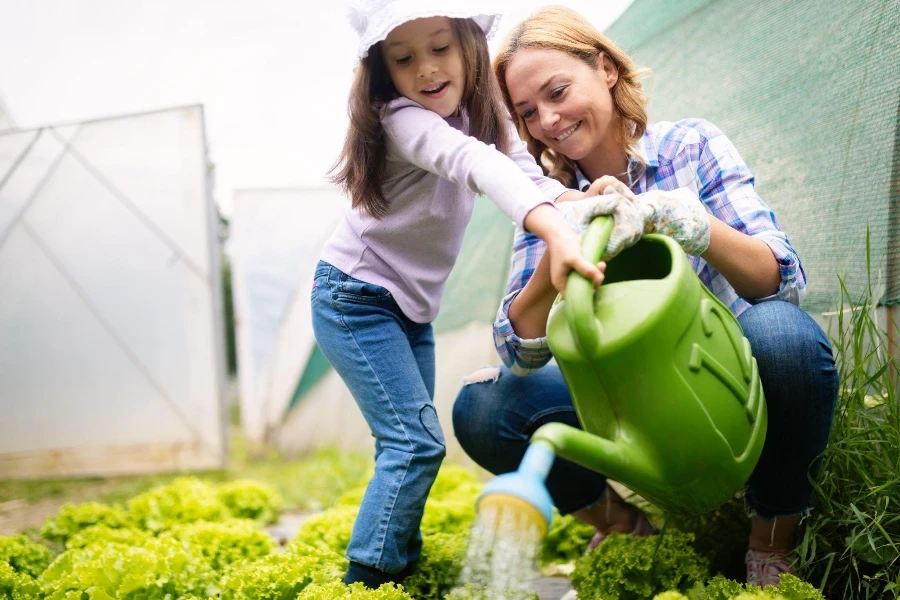 Beautiful young female farmer working in garden with her daughter