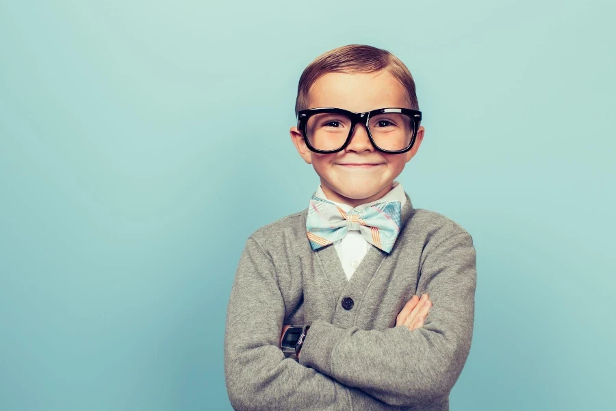 A young boy dressed as a nerd with glasses is looking in the camera