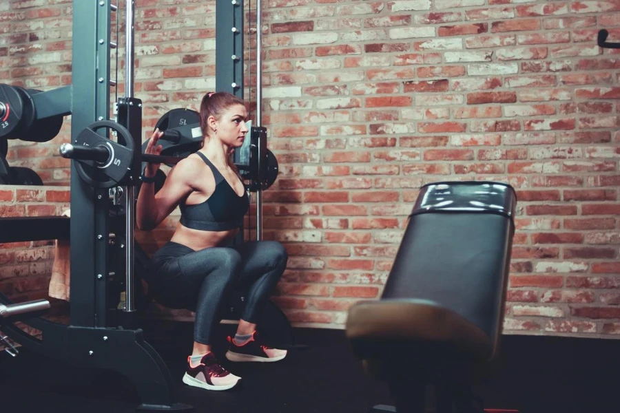 Concentrated sporty girl exercising squatting