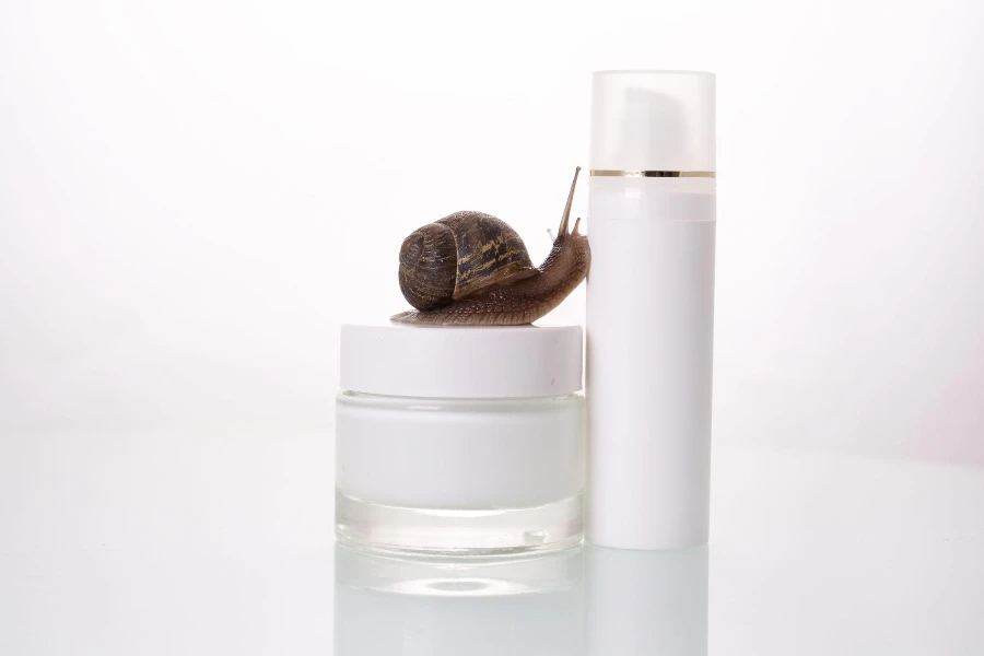 A snail streaking on a jar of skin cream