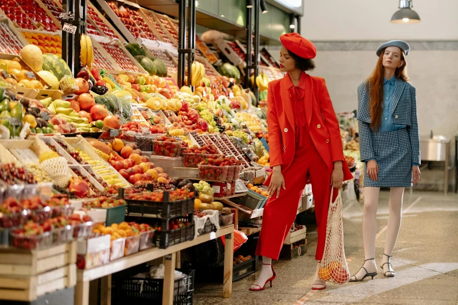 Women in Fashionable Clothes Standing Near the Fruit Stand