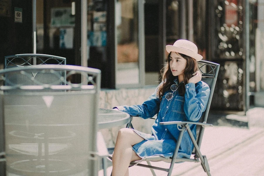 A Woman in Denim Dress Sitting on a Chair