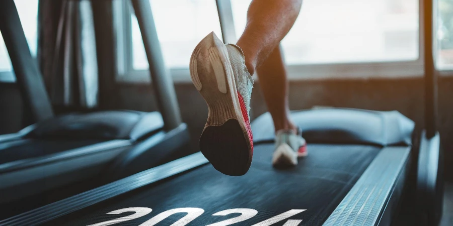 sportsman runner running on treadmill in fitness club