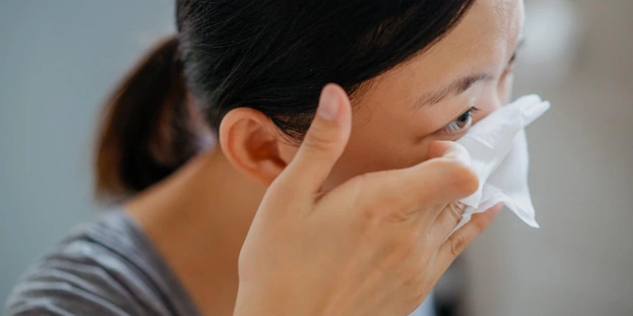Mujer asiática joven que quita el maquillaje