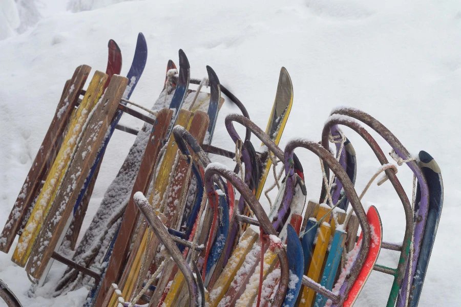 Many old children sledges are standing in the snow