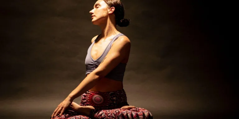 A young yoga practitioner with close tied dark hair