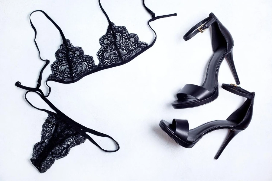 black lace underwear and black sandals with high heels on a light background
