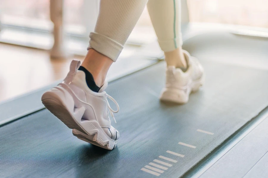 flou sélectif des jambes qui courent sur un tapis de marche